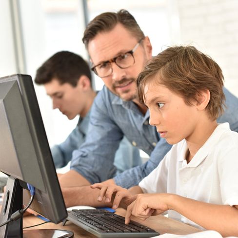 profesor enseñando a niños con ordenador
